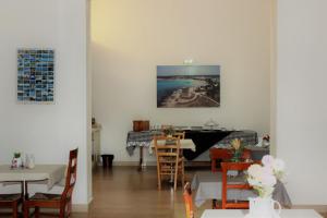 a dining room with white walls and tables and a piano at Casina Raho B&B in Nardò