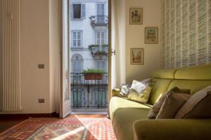 sala de estar con sofá y puerta abierta en Madeleine apartments - Residenza Belle Époque, en Milán