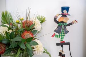 a wooden man in a top hat on a wall next to flowers at Madeleine apartments - Residenza Belle Époque in Milan