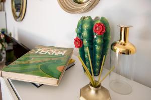 una mesa con un libro y un jarrón con dos rosas en Madeleine apartments - Residenza Belle Époque, en Milán 26 fotos más
