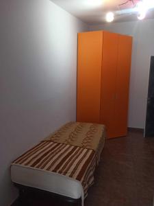 - une chambre avec un lit et une armoire orange dans l'établissement Open house, à Campofelice di Roccella