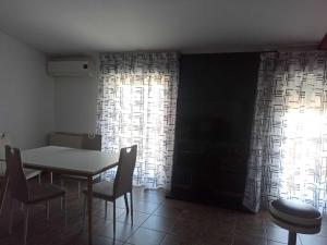 d'une salle à manger avec une table, des chaises et une fenêtre. dans l'établissement Open house, à Campofelice di Roccella