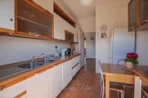a kitchen with a sink and a wooden table at vista sul blu ,Baia Blu, Lerici in Lerici