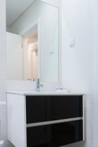 uma casa de banho com um lavatório e um espelho em Casa dos Terraços Apartamentos em São Martinho do Porto