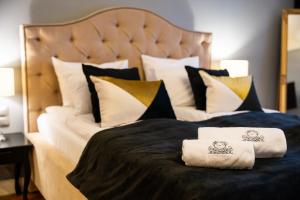 łóżko z dwoma ręcznikami na górze w obiekcie Apartamenty Pod Zegarem w mieście Mikołajki