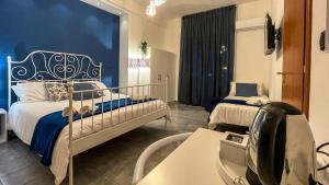 a bedroom with two beds and a blue wall at CinqueStanze in Cosenza
