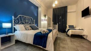 a bedroom with a large bed with a blue wall at CinqueStanze in Cosenza