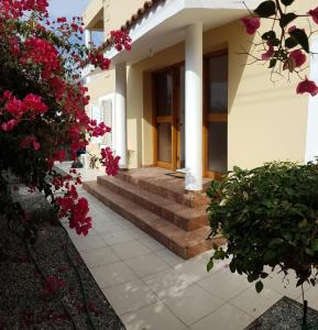 een huis met bloemen en trappen ervoor bij Paphos Apartment with Private Pool in Mesoyi