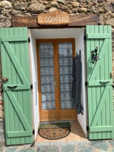 uma entrada para uma casa com portas verdes em A Casetta d’Hélène et Jeanette em Omessa