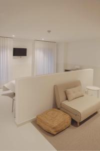 a white living room with a couch and a stool at HOTEL LA FONDA B&B in Tarazona de Aragón