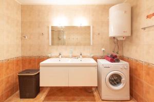 uma casa de banho com um lavatório e uma máquina de lavar roupa em Casa al Mar em Sveti Vlas