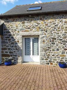 a stone house with a door and a brick driveway at La maison aux papillons in Tregueux