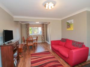 a living room with a red couch and a table at 2 Green Close in Southampton