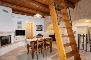 a dining room and living room with a wooden ladder at Trulli Quercus in Alberobello