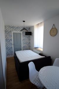 een kleine slaapkamer met een bed en een tafel bij Villa Jean Julien - Le Capucin - Appartement T1 - 1 chambres - 4 personnes in Le Mont-Dore