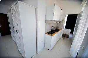 a white bathroom with a sink and a mirror at Stef by Loft Oxygen in Jupiter