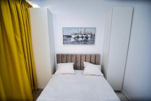 a bed with two pillows and a picture of boats at Stef by Loft Oxygen in Jupiter