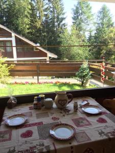 stół z talerzami i dzbanek do herbaty w obiekcie Casetta dei Cuori - Alpine Style Cozy Apartment w mieście Folgarida