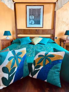 una camera da letto con un letto con piumone e cuscini blu di villa porta a colle a Castiglione della Pescaia