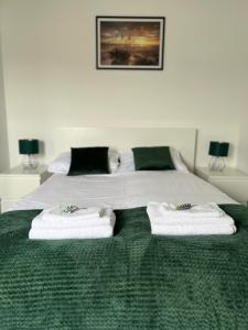 a bedroom with a bed with two towels on it at Apartament Opal - ul. Grunwaldzka przy plaży in Pobierowo