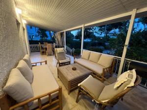 weranda z kanapą, krzesłami i stołem w obiekcie Koko's summer house w mieście Nea Makri