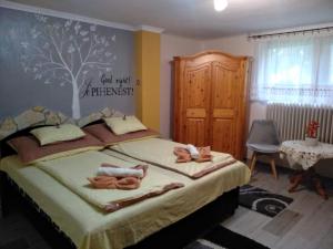 um quarto com uma cama com duas bonecas em Margaréta Panzió em Sárospatak
