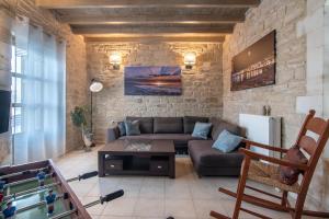 a living room with a couch and a stone wall at Alexandros Villa in Skouloúfia