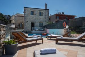 a patio with two lounge chairs and a swimming pool at Alexandros Villa in Skouloúfia