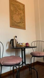 a table with two chairs and a tea kettle on it at Brezza Affittacamere in Montemarciano