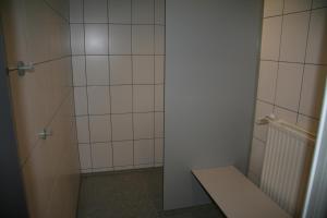 baño con ducha y banco. en Tiny rooms @ camping val d'Or, en Enscherange