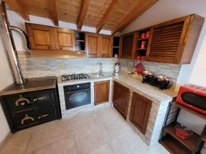 una cucina con armadi in legno e piano cottura. di Il Casale di Lucullo a Lucignano