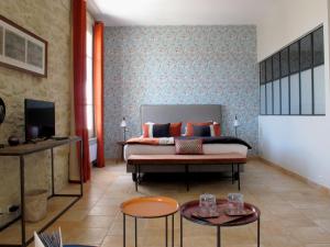 Sala de estar con 1 cama y 2 mesas en La Cour Des Sens, en Lagnes