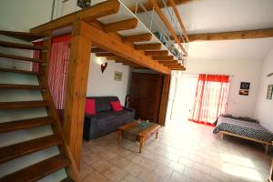 sala de estar con escalera y sofá en Loft avec mezzanine, en Montagnac