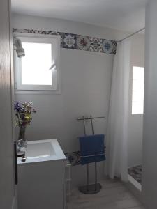 La salle de bains est pourvue d'un lavabo et d'une chaise bleue. dans l'établissement Piso De La Ermita, à Mijas