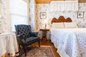 una camera da letto con un letto, una sedia e una finestra di Captain Mey's Inn a Cape May