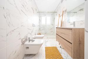 La salle de bains blanche est pourvue de toilettes et d'un lavabo. dans l'établissement Apartamento situado no centro histórico da cidade, à Setúbal