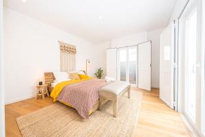 ein Schlafzimmer mit einem Bett mit einer gelben Decke in der Unterkunft Apartamento situado no centro histórico da cidade in Setúbal + 33 Fotos