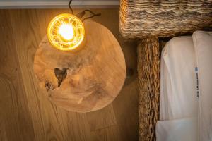 une table ronde en bois avec une lumière sur un mur dans l'établissement Apartamento situado no centro histórico da cidade, à Setúbal