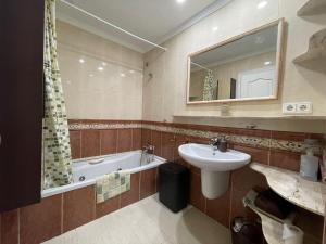 a bathroom with a sink and a bath tub at Aires de Regla, Apartamentos Living Sur in Chipiona