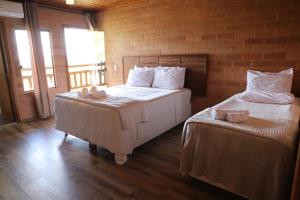 um quarto com 2 camas e uma parede de tijolos em Woodstock guesthouse em Alto Paraíso de Goiás