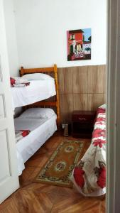Habitación con 2 literas y alfombra. en Hst Ateliê Marli Marques, en Pelotas