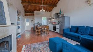 een woonkamer met een blauwe bank en een keuken bij Pesci in Gaiole in Chianti