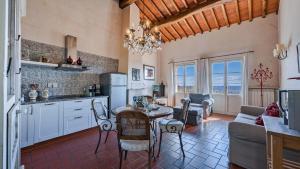 een keuken en woonkamer met een tafel en stoelen bij Scorpione in Gaiole in Chianti