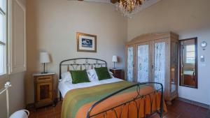 een slaapkamer met een bed met groene kussens en een kroonluchter bij Scorpione in Gaiole in Chianti +31 foto's