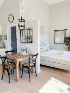 ein Esszimmer mit einem Tisch, Stühlen und einem Bett in der Unterkunft Ferienwohnung Baltic Idyll in Scharbeutz
