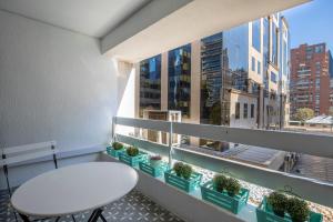 d'un balcon avec une table blanche et quelques plantes. dans l'établissement Apartment - El Golf - Costanera Center, à Santiago