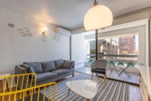 ein Wohnzimmer mit einem Sofa und einem Tisch in der Unterkunft Apartment - El Golf - Costanera Center in Santiago