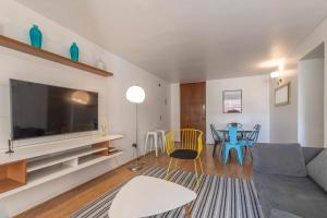ein Wohnzimmer mit einem großen TV und einem Tisch in der Unterkunft Apartment - El Golf - Costanera Center in Santiago