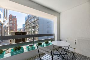 d'un balcon avec une table, des chaises et une fenêtre. dans l'établissement Apartment - El Golf - Costanera Center, à Santiago