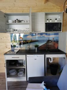 eine Küche mit einer Spüle und einer Arbeitsplatte in der Unterkunft Domki Marcus in Rowy
